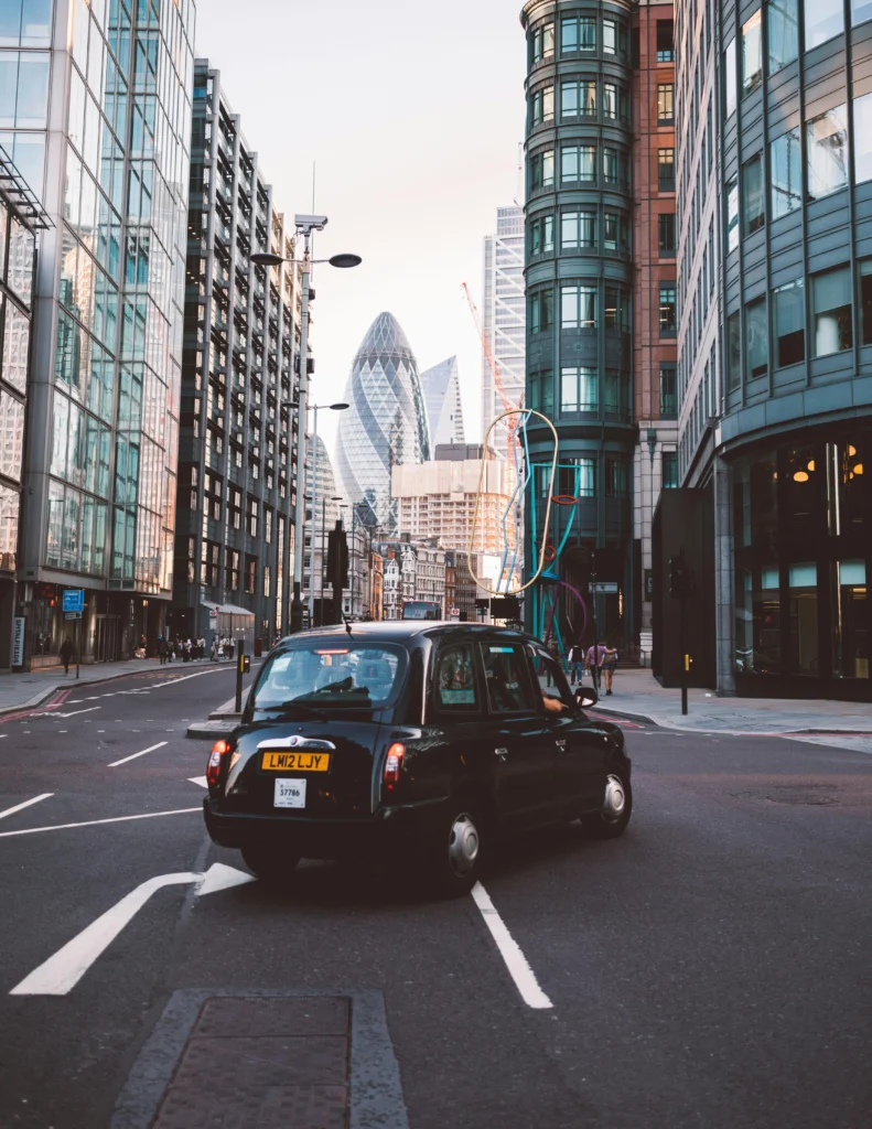 shot of a London black cab in the middle of a road. London Instagram captions